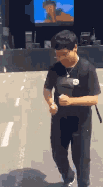 a young man is walking down a street in front of a stage .