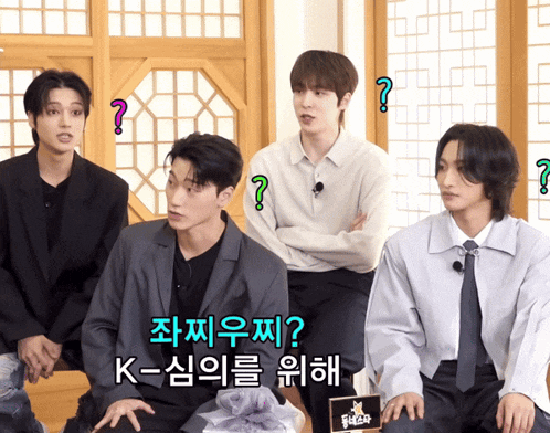 a group of young men are sitting in front of a sign that says k-ism on it