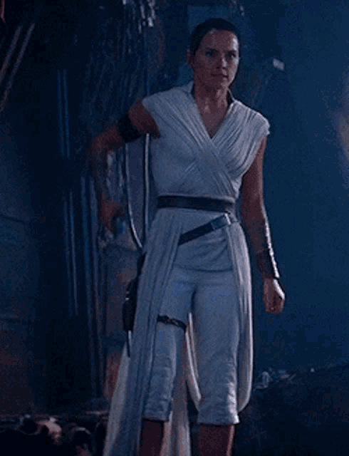 a woman is holding a light saber in a dark room .