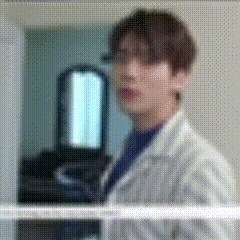 a blurred image of a man in a lab coat standing in front of a mirror