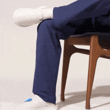 a person sitting on a chair with their legs crossed