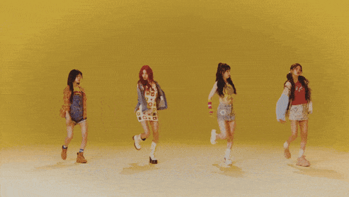 two women are standing next to each other on a yellow background . one of the women has red hair .