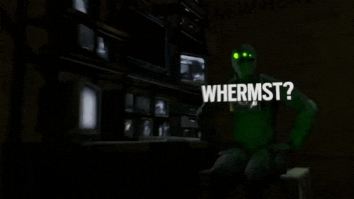 a man in a green suit is standing in front of a monitor with the words whermst written above him