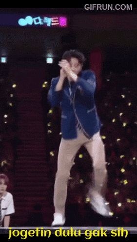 a gif from gifrun.com shows a man in a suit and tie doing a dance