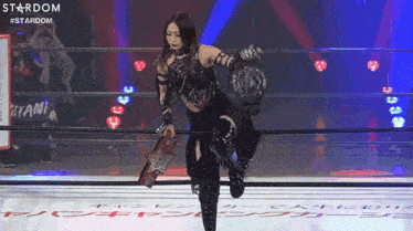a woman in a wrestling ring holding a championship belt