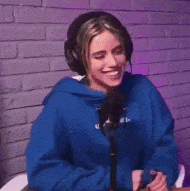 a woman wearing headphones is dancing in front of a microphone .