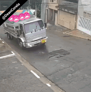 a mantle truck is driving down a street in front of a building