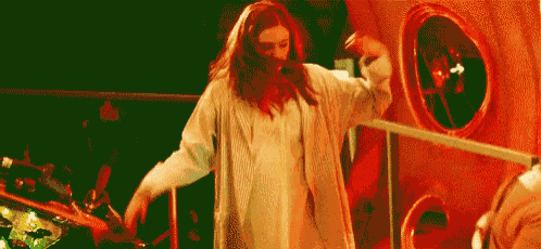 a woman with red hair is standing in front of a mirror