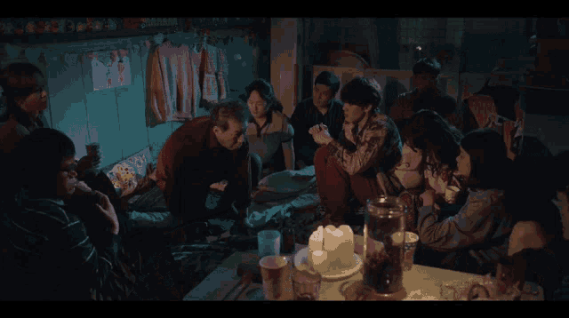 a group of people are sitting in a room with a drawing on the wall that says ' i love you '