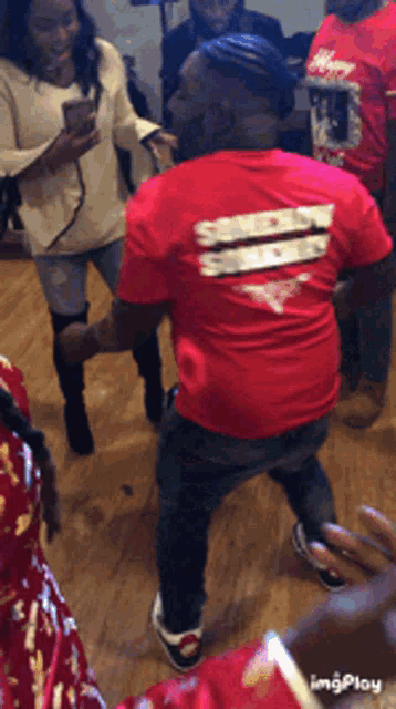 a man wearing a red shirt that says smoke show is dancing