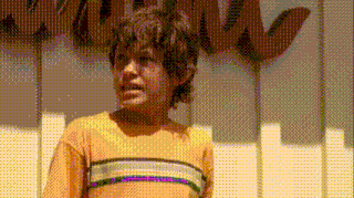 a pixelated image of a boy standing in front of a piano keyboard .
