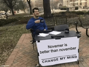 a man is sitting at a desk with a sign that says november is better than november