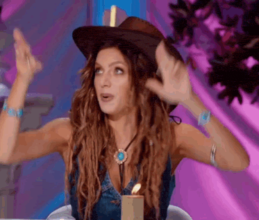 a woman wearing a cowboy hat is sitting at a table