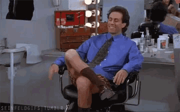 a man is sitting in a chair with his legs crossed