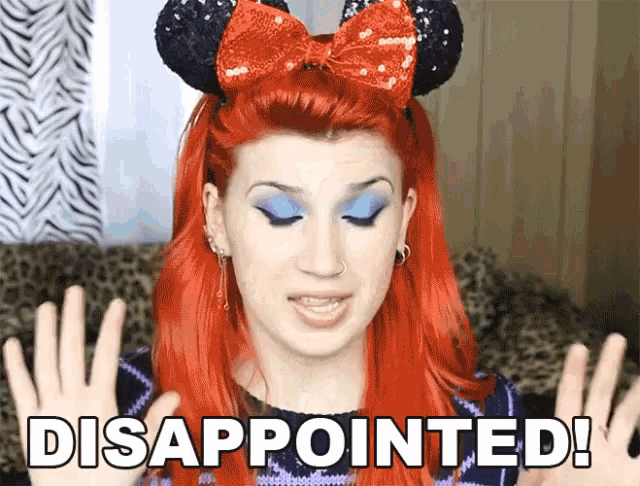 a woman with red hair wearing a minnie mouse headband has disappointed written on her hands
