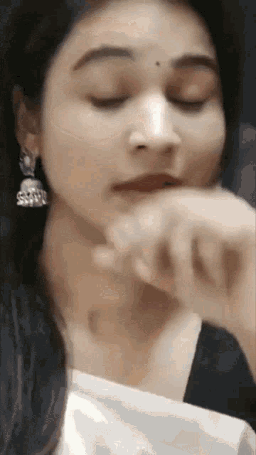 a close up of a woman 's face with earrings on