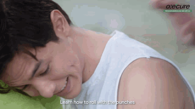 a man in a white tank top is smiling with the words learn how to roll with the punches behind him