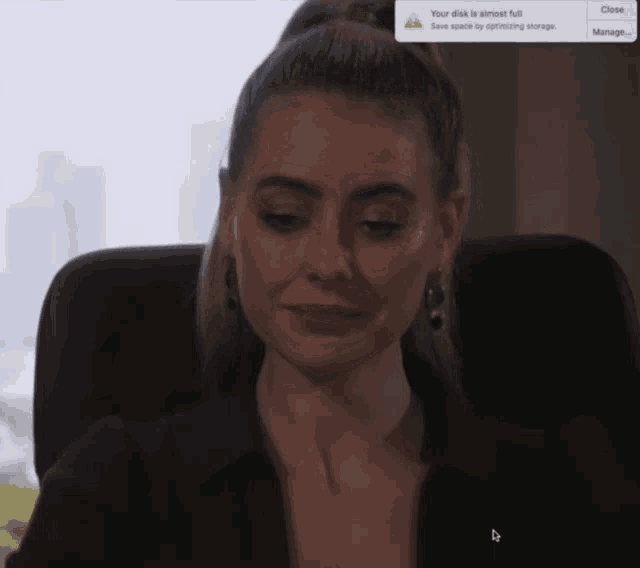 a woman sitting in front of a screen that says " your disk is almost full "