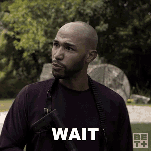 a man is holding a gun and the word wait is on the bottom
