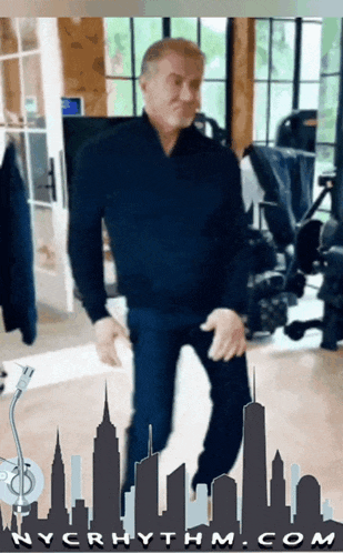 a man is dancing in front of a city skyline with nycrhythm.com at the bottom