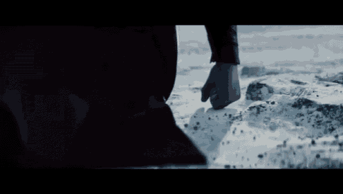 a person is standing in the water with their fist in the air .