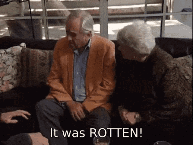 a man and a woman sit on a couch with the words " it was rotten " written below them