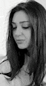 a black and white photo of a woman with long hair looking down with her eyes closed .