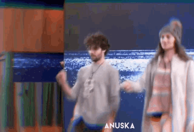 a man and a woman are dancing in front of an advertisement for anuska