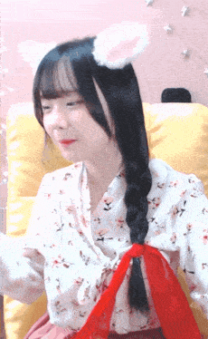 a girl wearing a white cat ear headband is sitting in a chair