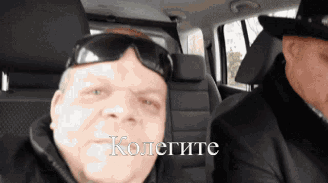 a man wearing sunglasses and a hat is sitting in the back seat of a car with the word kolegite written on his face
