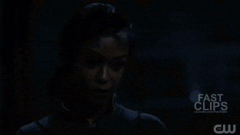 a woman is standing in the dark with a fast clips logo in the background .