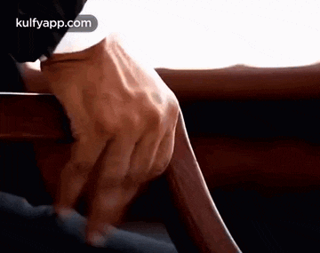 a close up of a person 's hand holding a wooden table .