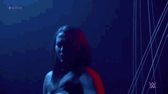 a woman is standing in a dark room surrounded by ropes and looking at the camera .