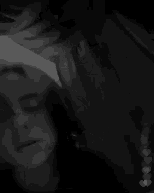 a black and white photo of a person 's face with their eyes closed .