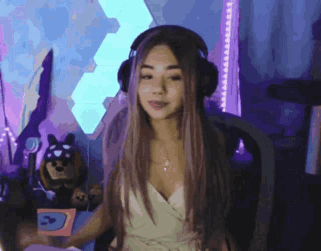 a woman wearing headphones is sitting in front of a purple background