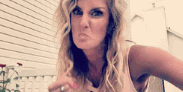 a woman with long blonde hair is making a funny face
