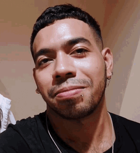 a man with a piercing in his lip is smiling for the camera