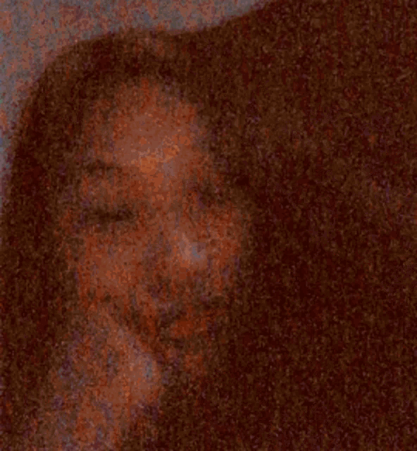 a close up of a woman 's face with a hand on her chin .