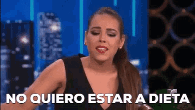 a woman in a black dress is saying no quiero estar a dieta .