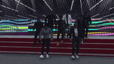 a group of people are dancing in front of a colorful backdrop