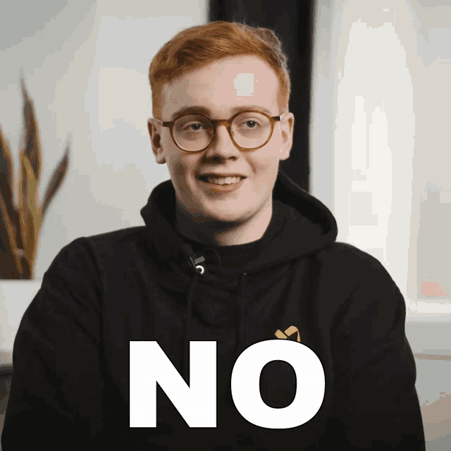 a man wearing glasses and a black hoodie with the word no in white letters