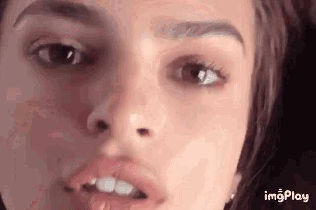 a close up of a woman 's face with her mouth open and her tongue out .