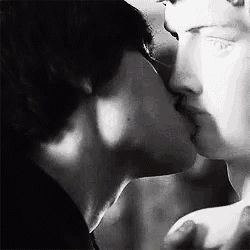 a black and white photo of two men kissing .