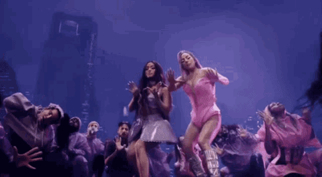 a group of women are dancing together on a stage .