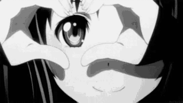 a black and white photo of a girl making a heart shape with her hands around her eyes .