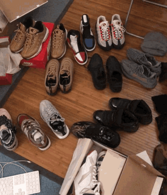 a bunch of shoes on a wooden floor with a box that says nike