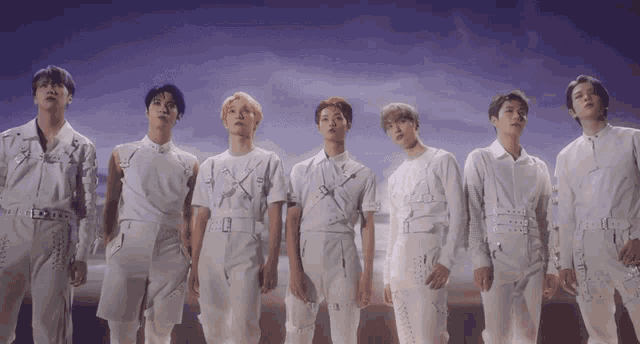 a group of young men standing next to each other in white