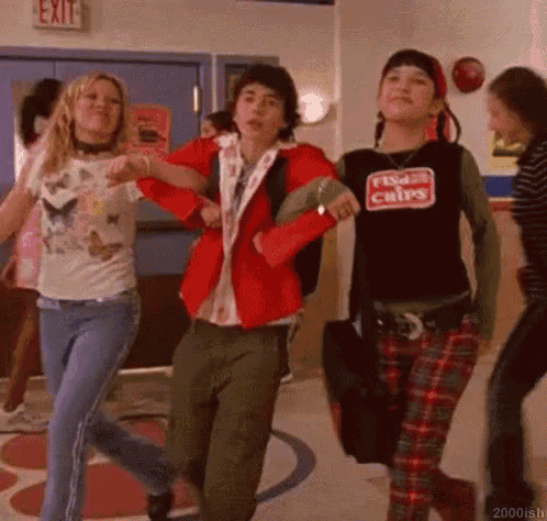 a group of people are dancing in a hallway and one of them is wearing a shirt that says fish 's chips