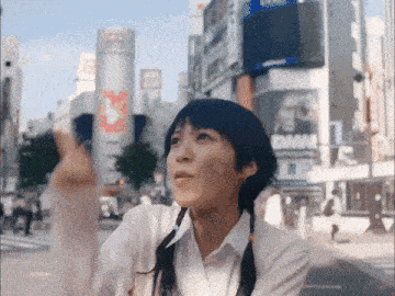 a woman with a bandage on her face stands in front of a building that says dmm on it