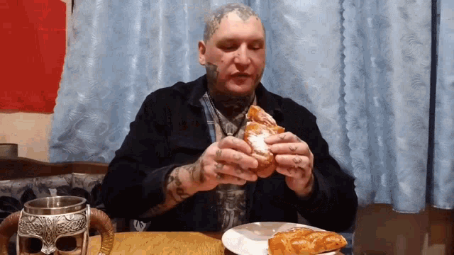 a man with a tattoo on his head is eating a piece of pizza